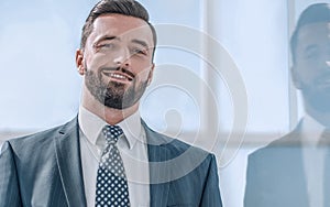 Portrait of a businessman on the background of an office window