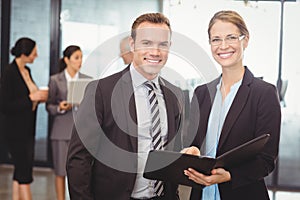Portrait of businessman and businesswoman holding file