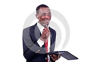 Portrait of a businessman communicating using a tablet and headphones, smiling