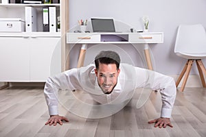 Portrait Of A Businessman Doing Push Up On Floor