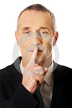 Portrait of businessman gesturing silent sign