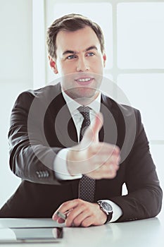 Portrait of businessman giving hand for handshake.