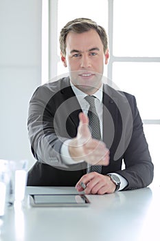 Portrait of businessman giving hand for handshake.