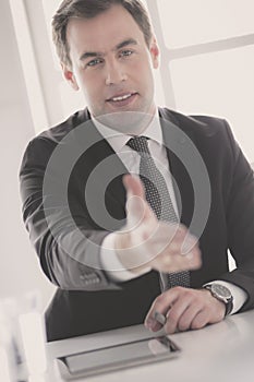 Portrait of businessman giving hand for handshake.