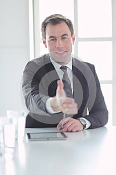 Portrait of businessman giving hand for handshake.