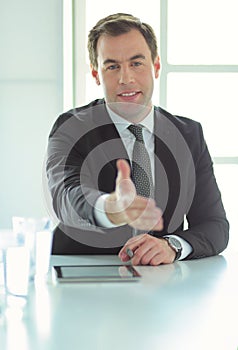 Portrait of businessman giving hand for handshake.