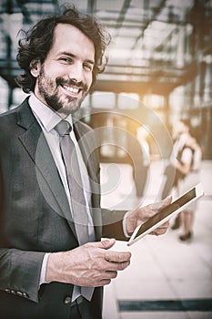 Portrait of businessman holding digital tablet