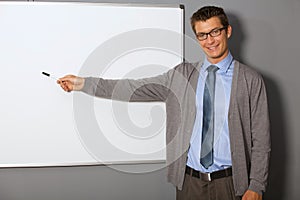 Portrait of businessman pointing at whiteboard in office