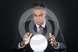 Portrait Of Businessman Predicting Future With Crystal Ball photo