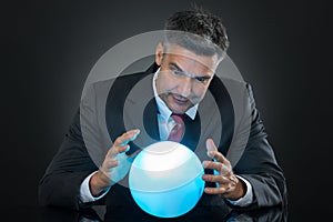 Portrait Of Businessman Predicting Future With Crystal Ball photo