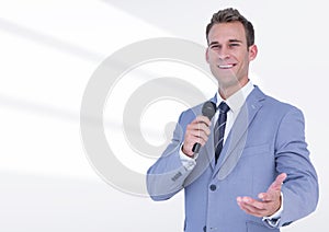 Portrait of businessman public speaking on microphone against white background