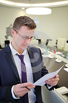 Portrait of businessman reading a document in the