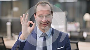 Portrait of Businessman showing Ok Sign with Finger