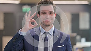 Portrait of Businessman showing Ok Sign with Finger