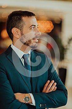 Portrait of a businessman in a suit with his arms crossed in a modern office building