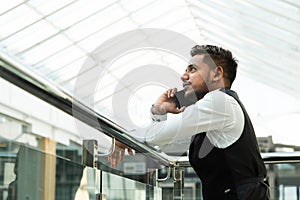 Portrait of a businessman in suit are standing on the background of glass offices.