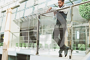 Portrait of a businessman in suit are standing on the background of glass offices.