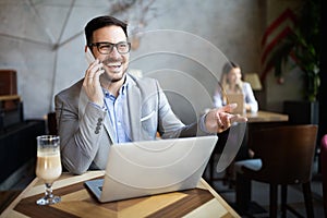 Portrait of businessman working, talking on mobile phone in office