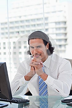 Portrait of a businessman thinking while using a monitor