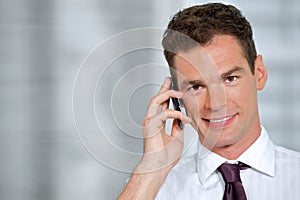 Portrait of businessman using mobile phone at office