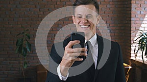 Portrait of Businessman using smartphone. Reaction of Win, Success by Excited Man get good news on his smart phone.