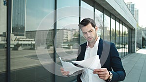 Portrait of businessman walking in slow motion. Business man throwing papers