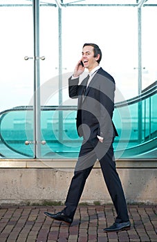 Portrait of a businessman walking and talking on mobile phone