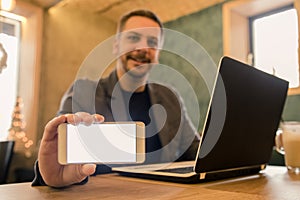 Portrait of businessman who using laptop and showing blank scree