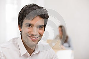 Portrait of businessman working on computer in office, looking c