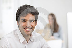 Portrait of businessman working on computer in office, looking c