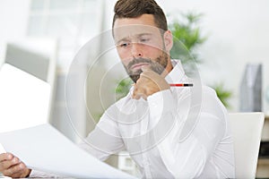Portrait businessman working on paperwork in office
