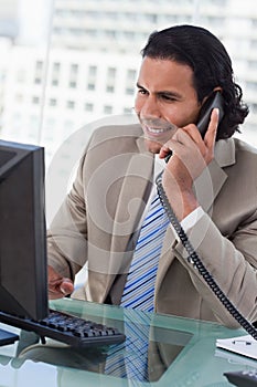 Portrait of a businessman working with a monitor while being on