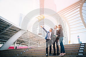 Portrait of businessteam pointing up the future on blurred city background. Business success concept