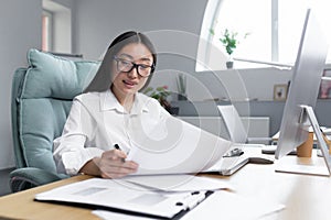 Portrait of a businesswoman Asian accountant works with documents and reports.Sitting in the office