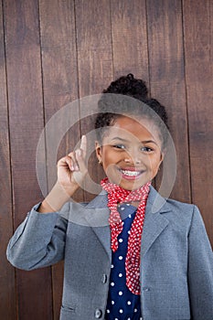 Portrait of businesswoman pointing upwards