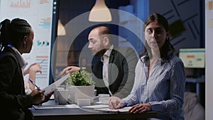 Portrait of businesswoman sitting at conference table in office meeting room working overtime