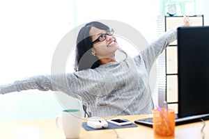 Portrait of businesswoman sitting at desk in the office relaxed