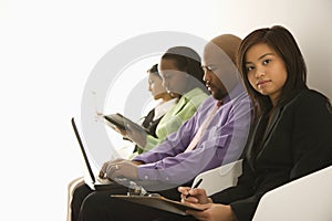 Portrait of businesswoman sitting with others.