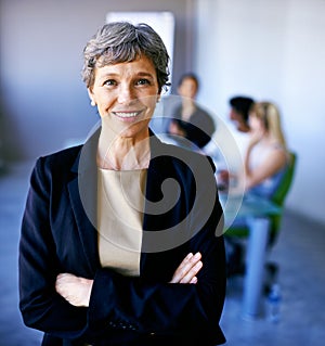 Discussing business strategy. Portrait of a businesswoman standing in front of her colleagues during a meeting.