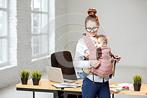 Businesswoman working with her baby son at the office