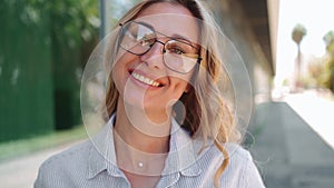 Portrait of businesswoman in trendy eyeglasses smiling at camera