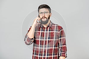 Portrait of busy adult man talking on phone, expressing seriousness