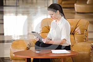 Portrait of busy business woman working while sitting at sofa