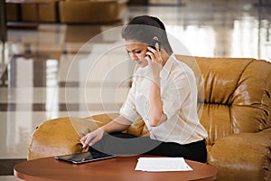 Portrait of busy business woman working while sitting at sofa.