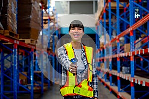 Portrait of Cacuasian warehouse worker hold barcode scaner and point at camera stay on way between shelves in workplace. Concept