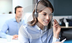 Portrait of call center worker accompanied by his team. Smiling customer support operator at work.