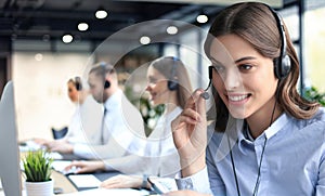 Portrait of call center worker accompanied by his team. Smiling customer support operator at work