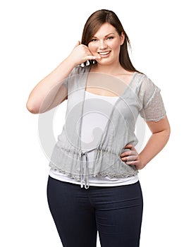 Portrait, call me hand gesture and a plus size woman in studio isolated on a white background for communication. Smile