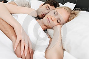 Portrait of calm handsome couple sleeping in bed