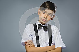 Portrait of calm and mistrust boy isolated on gray background. Normal human emotion, facial expression. Closeup